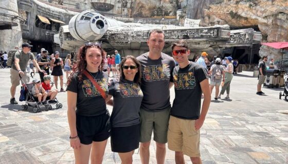 John Melendez and his family pose in front of the Millennium Falcon at Disney World
