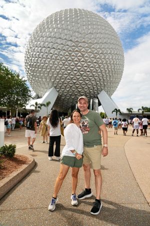 John Melendez and his wife pose in front of EPCOT's Spaceship Earth
